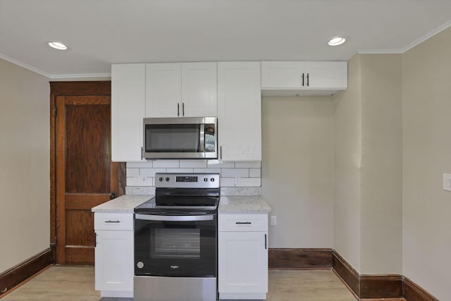 kitchen featuring light stone countertops, appliances with stainless steel finishes, tasteful backsplash, light hardwood / wood-style floors, and white cabinetry