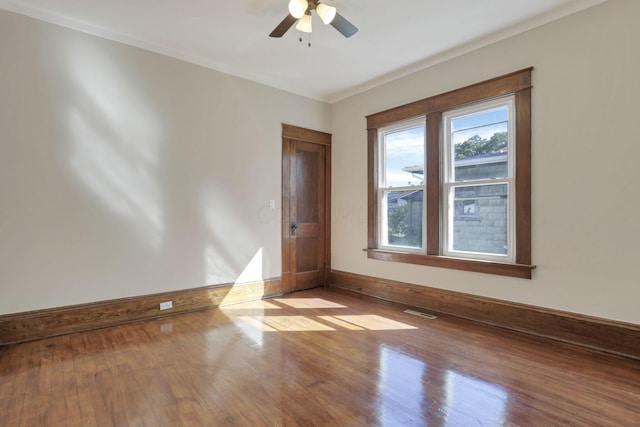 spare room featuring ceiling fan, light wood-type flooring, and crown molding