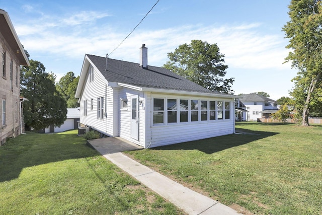 view of side of home with a yard and central air condition unit