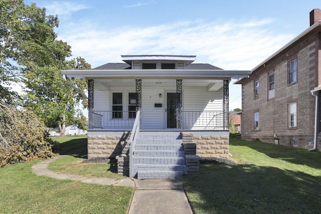 bungalow-style home featuring covered porch and a front yard