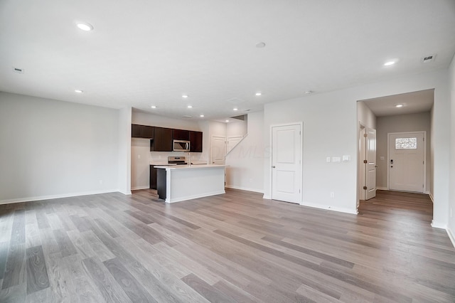 unfurnished living room with recessed lighting, visible vents, light wood finished floors, and baseboards