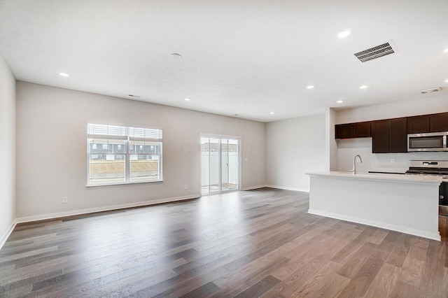 kitchen with light wood-type flooring, stainless steel appliances, visible vents, and open floor plan