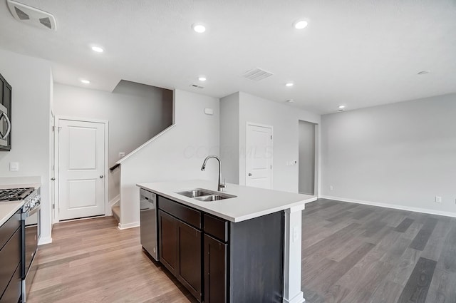 kitchen featuring a sink, stainless steel appliances, visible vents, and light countertops