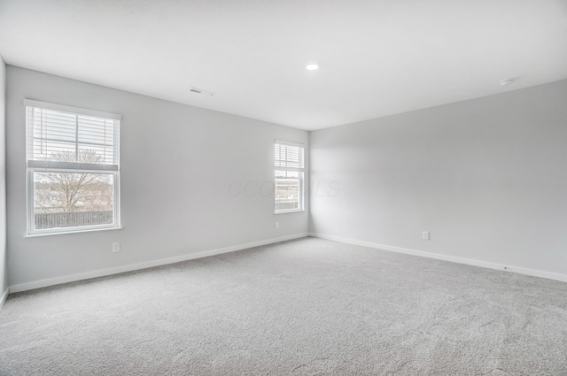 unfurnished room featuring visible vents, recessed lighting, baseboards, and carpet