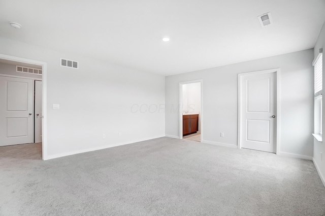 spare room with visible vents, light carpet, and baseboards