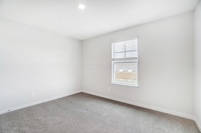 carpeted spare room with baseboards