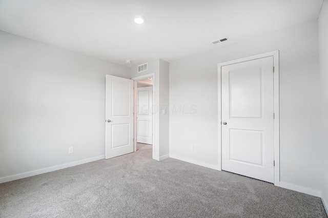 unfurnished bedroom featuring visible vents, baseboards, and carpet