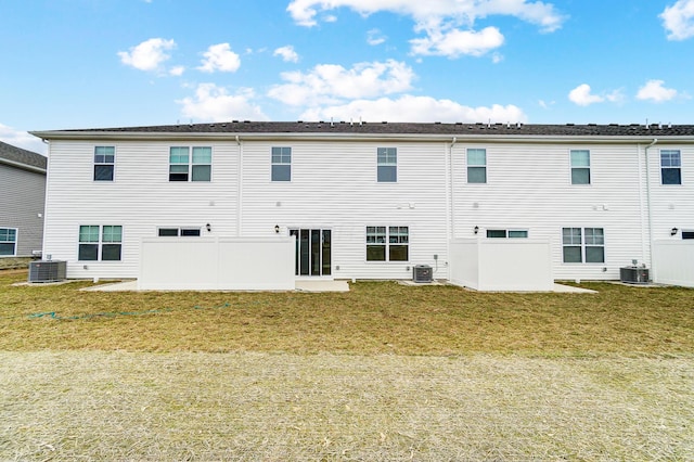 rear view of house with a yard and central AC