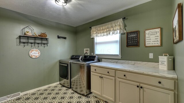 laundry room featuring cabinets, washing machine and dryer, and a textured ceiling