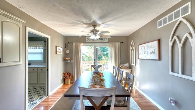 dining area with a textured ceiling, hardwood / wood-style flooring, and ceiling fan