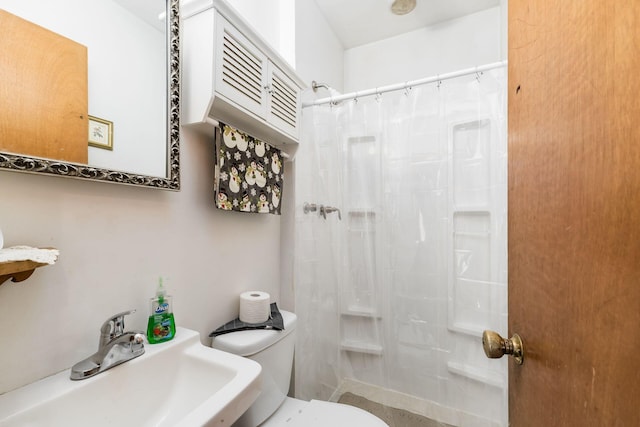 bathroom featuring a shower with shower curtain, toilet, and sink