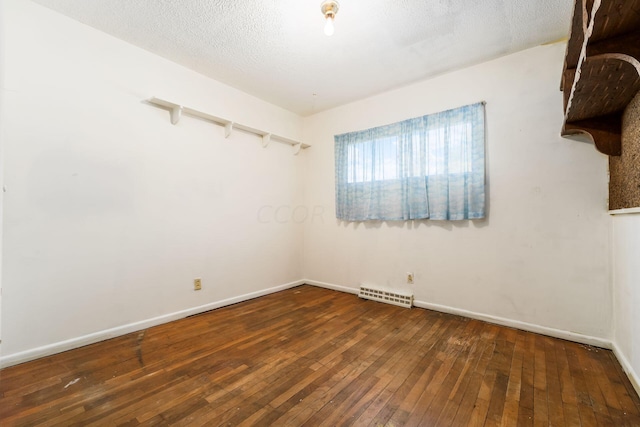 empty room featuring dark hardwood / wood-style flooring and a textured ceiling