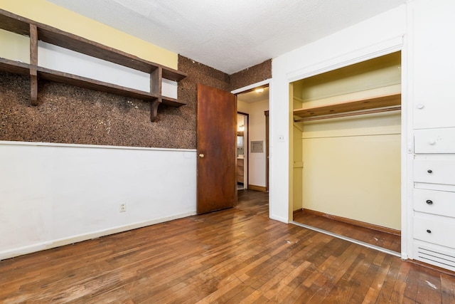 unfurnished bedroom featuring a textured ceiling and dark wood-type flooring