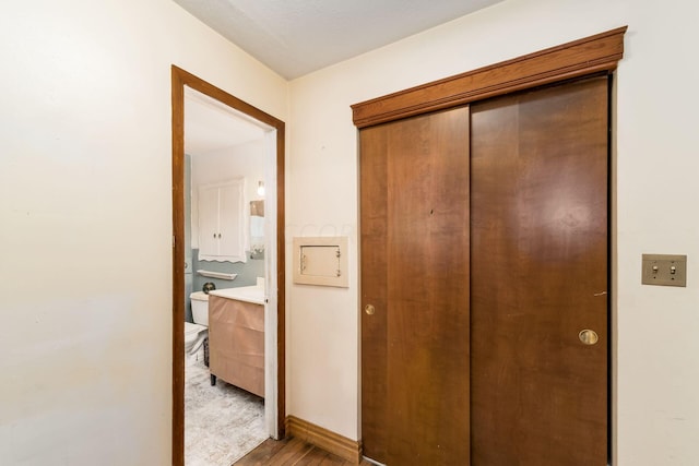 hall with light hardwood / wood-style flooring and a textured ceiling