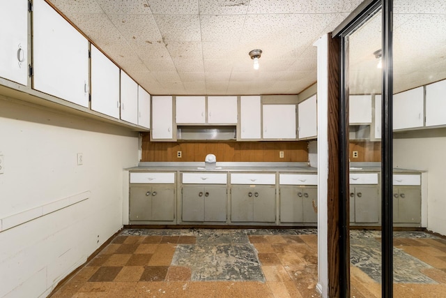 kitchen featuring white cabinetry and a drop ceiling