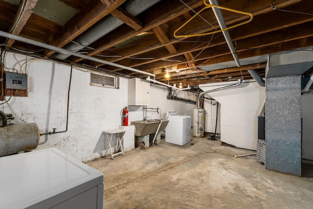 basement featuring electric panel, sink, washer / clothes dryer, and water heater