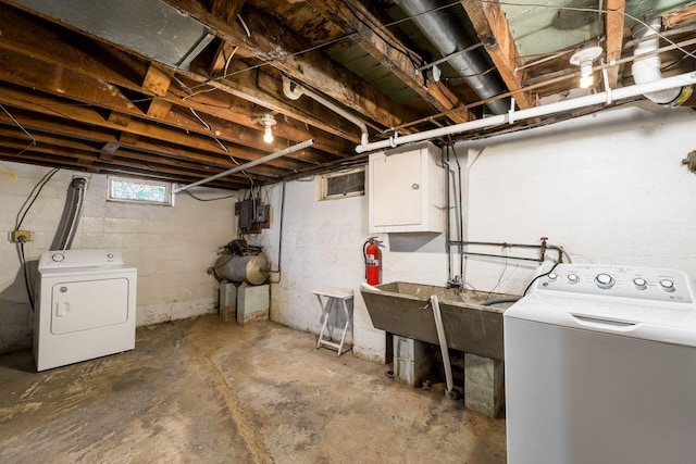 basement with electric panel and washer and clothes dryer