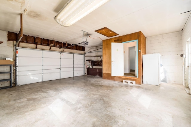 garage with white refrigerator and a garage door opener