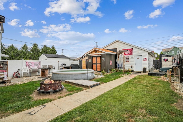 exterior space featuring a front lawn, a fire pit, and a storage shed