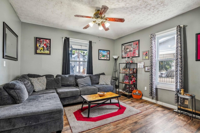 living room featuring hardwood / wood-style floors, a textured ceiling, ceiling fan, and a healthy amount of sunlight