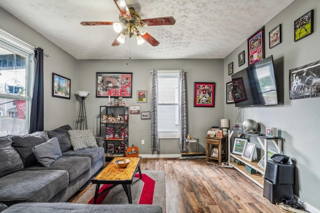 living room with a textured ceiling, hardwood / wood-style flooring, and ceiling fan