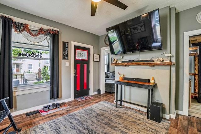 entrance foyer featuring a textured ceiling, ceiling fan, and dark hardwood / wood-style floors