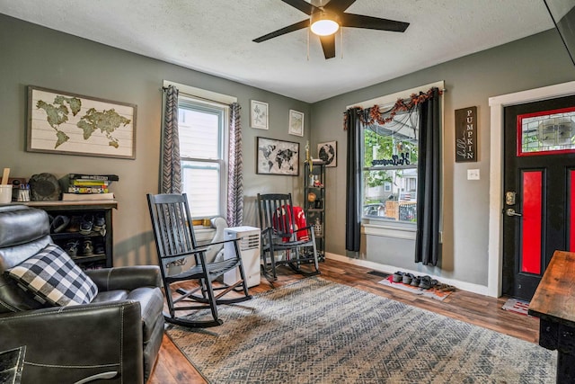 sitting room with a textured ceiling, hardwood / wood-style flooring, and ceiling fan