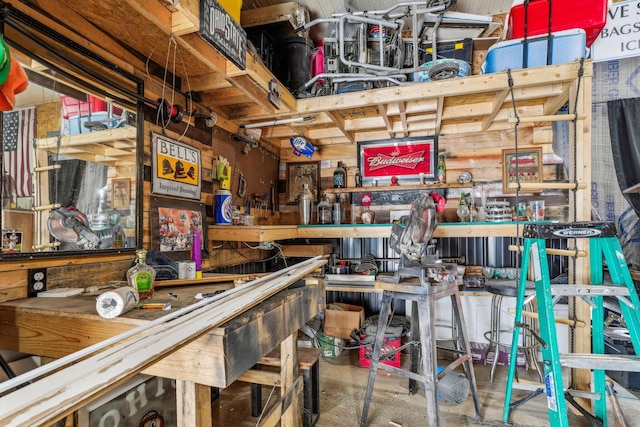 misc room featuring bar area, wooden walls, and concrete floors