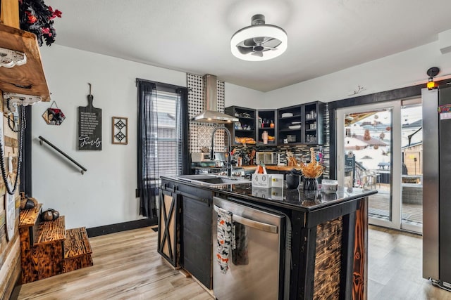 kitchen featuring a center island, wall chimney exhaust hood, sink, light hardwood / wood-style flooring, and stainless steel dishwasher