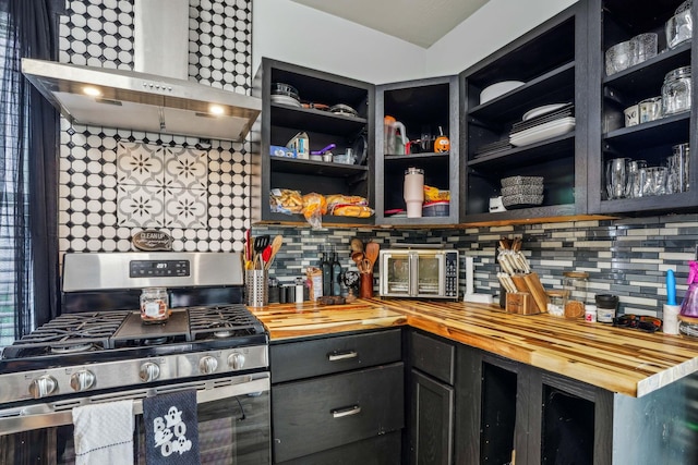 kitchen with butcher block countertops, gas range, and wall chimney range hood