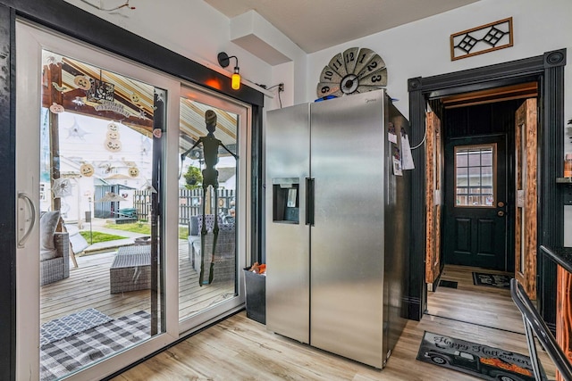 kitchen with stainless steel refrigerator with ice dispenser, light hardwood / wood-style flooring, and plenty of natural light