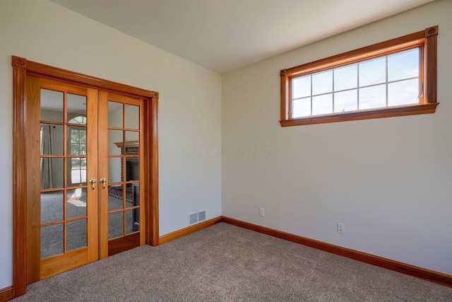 unfurnished room with carpet and french doors