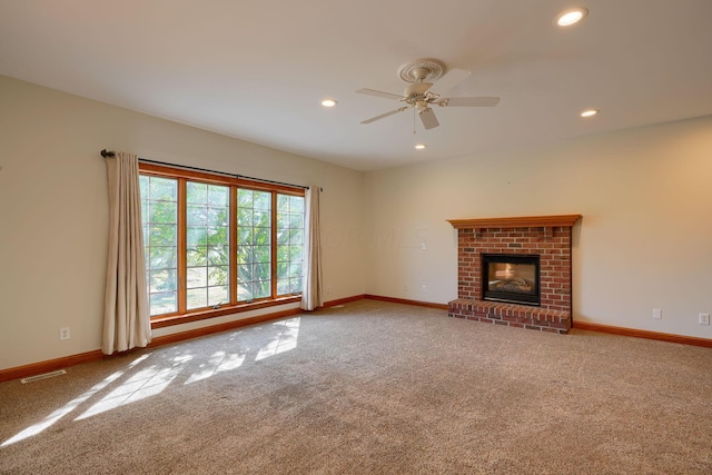 unfurnished living room featuring ceiling fan, a fireplace, and carpet