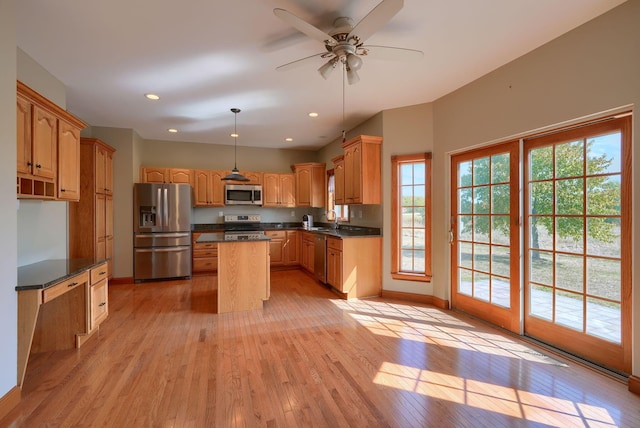 kitchen with stainless steel appliances, a kitchen island, light hardwood / wood-style floors, and sink