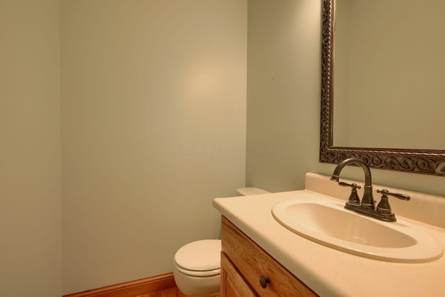 bathroom with vanity, toilet, and wood-type flooring