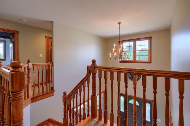 stairs with a notable chandelier and plenty of natural light