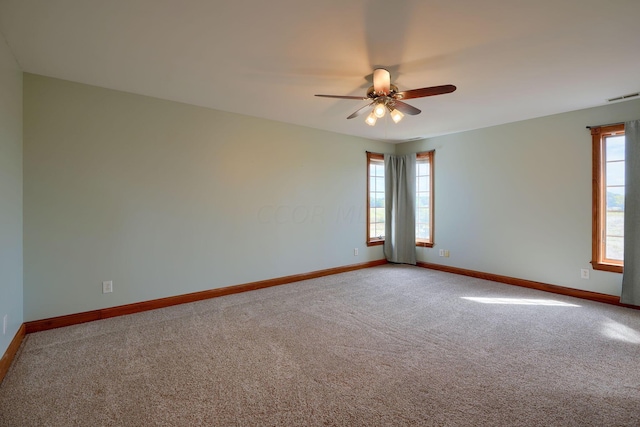 unfurnished room featuring carpet flooring, a wealth of natural light, and ceiling fan