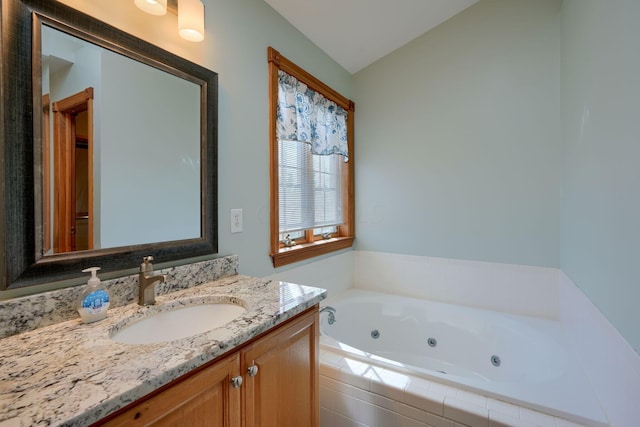 bathroom with tiled bath, vanity, and vaulted ceiling