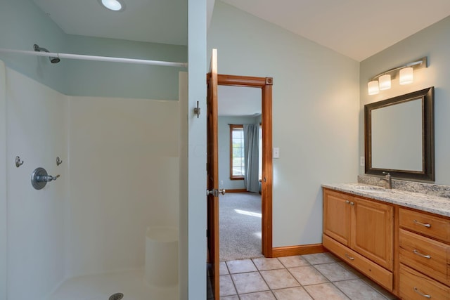 bathroom with tile patterned flooring, vanity, a shower, and vaulted ceiling