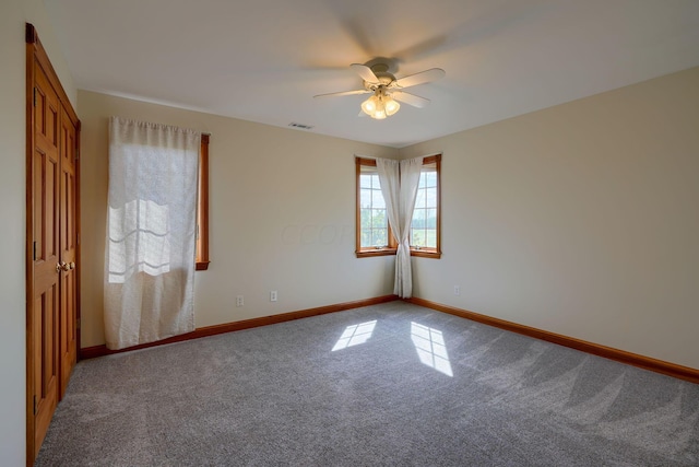 carpeted spare room featuring ceiling fan