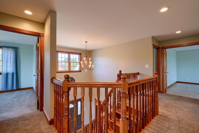 corridor featuring carpet flooring and an inviting chandelier