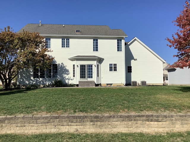 view of front of property featuring a front yard and central AC unit