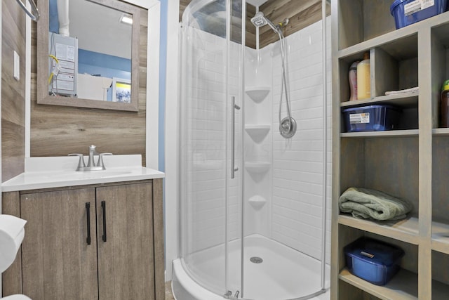 bathroom with wooden walls, vanity, and an enclosed shower