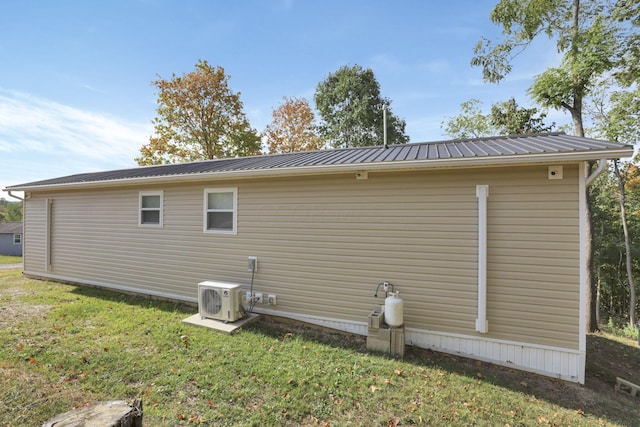 view of property exterior with ac unit and a yard