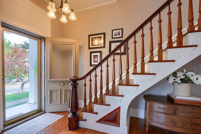 entryway featuring hardwood / wood-style flooring, an inviting chandelier, and ornamental molding