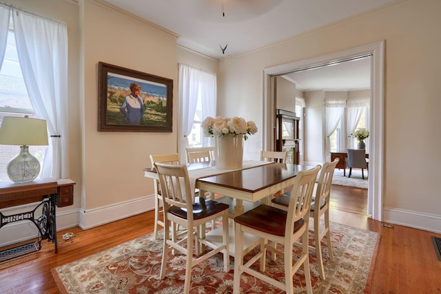 dining room with a wealth of natural light, light hardwood / wood-style flooring, and ornamental molding