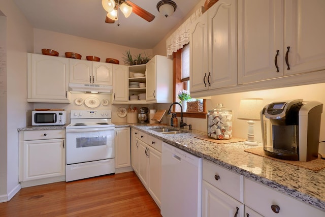 kitchen featuring light stone countertops, white appliances, sink, light hardwood / wood-style floors, and white cabinetry