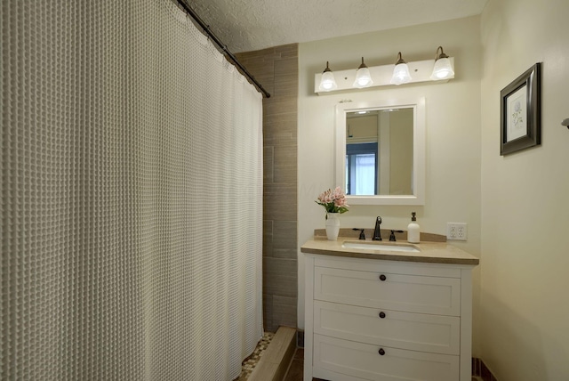 bathroom featuring vanity, a textured ceiling, and walk in shower