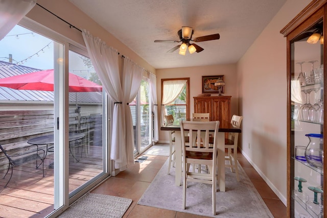 dining room featuring ceiling fan, light tile patterned floors, and a textured ceiling