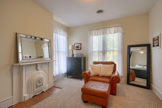 sitting room with a wealth of natural light and light carpet